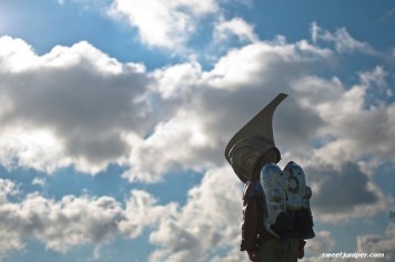 kid with helmet and rocket on back against backdrop of cloudy sky