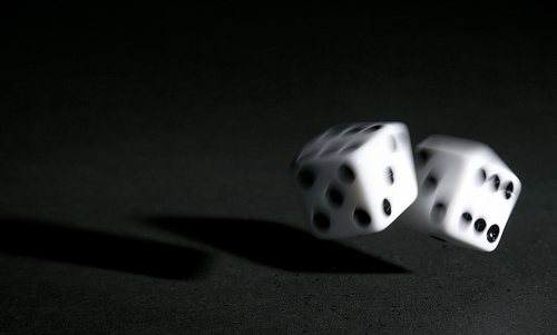 Image of two dice rolling in mid-flight