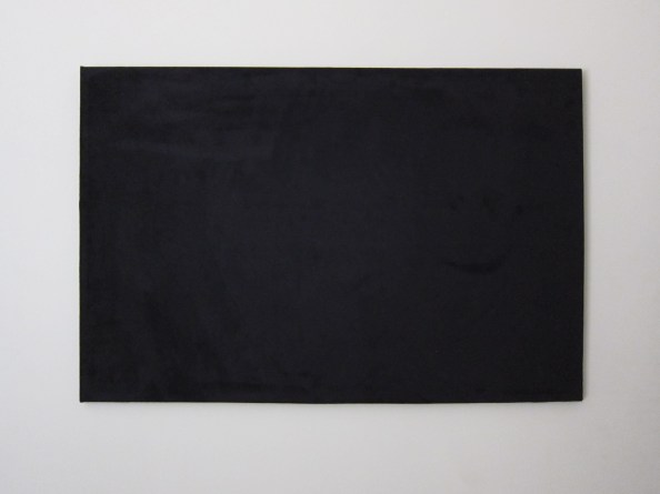blank black canvas hanging on a cream wall