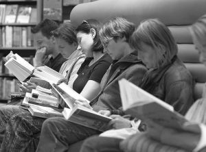 row of people sitting and reading what appears to be the same book